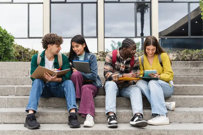 Diverse group of college students studying together on campus steps