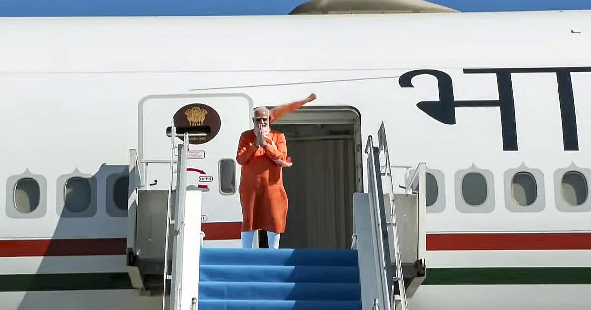 PM Modi waves from airplane stairs in Australia, signaling business talks.