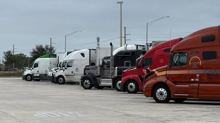Trucks lined up, potentially impacting trucker jobs discussed in politics.