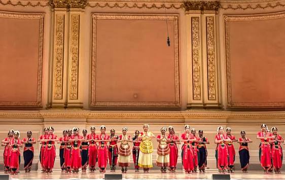 Indian dancers in colorful costumes perform on stage, showcasing rich culture.