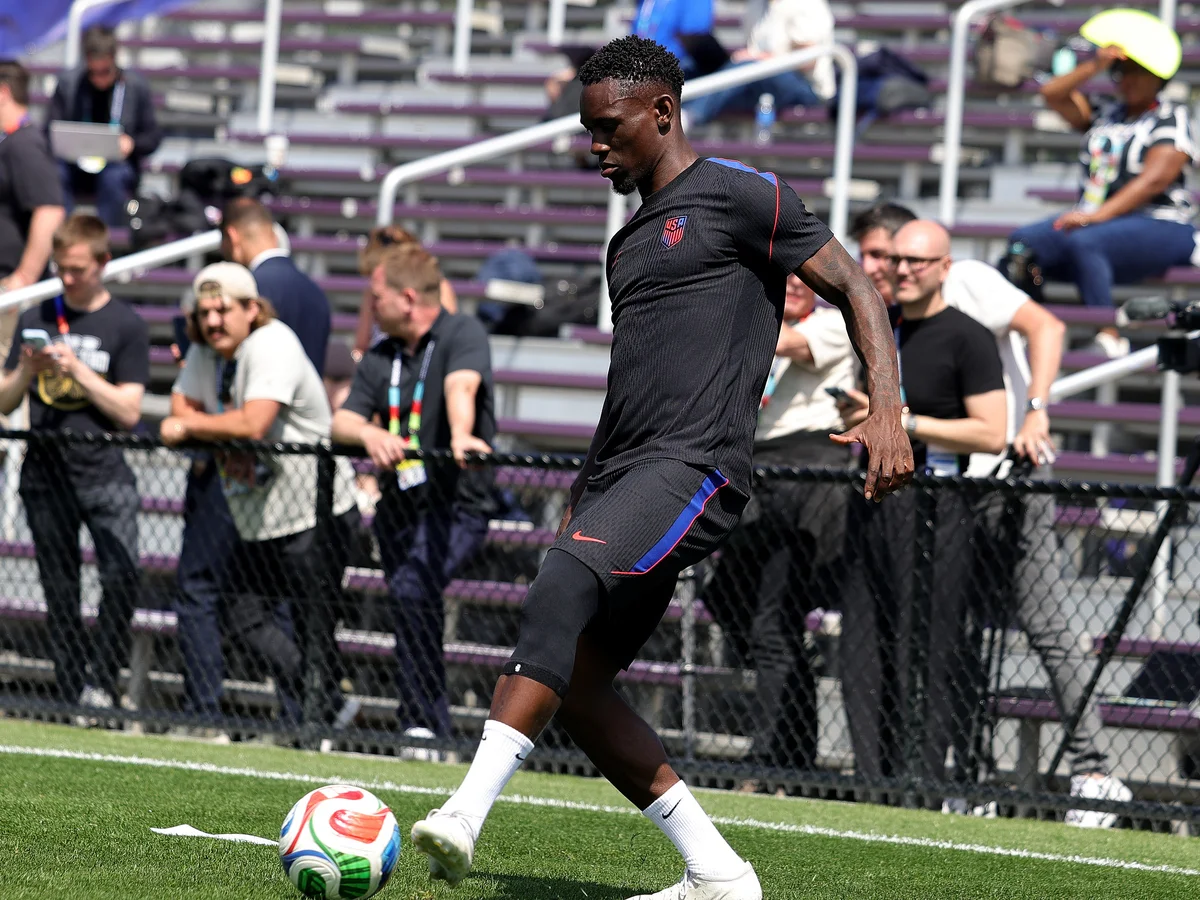 Soccer player Folarin Balogun practicing with a ball, with crowd in background