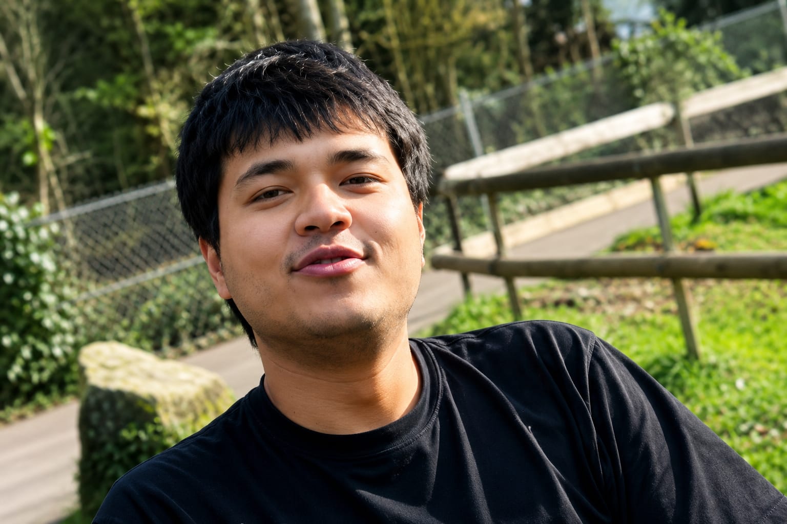 Uyghur man smiling outdoors, relevant to visa and immigration discussions.