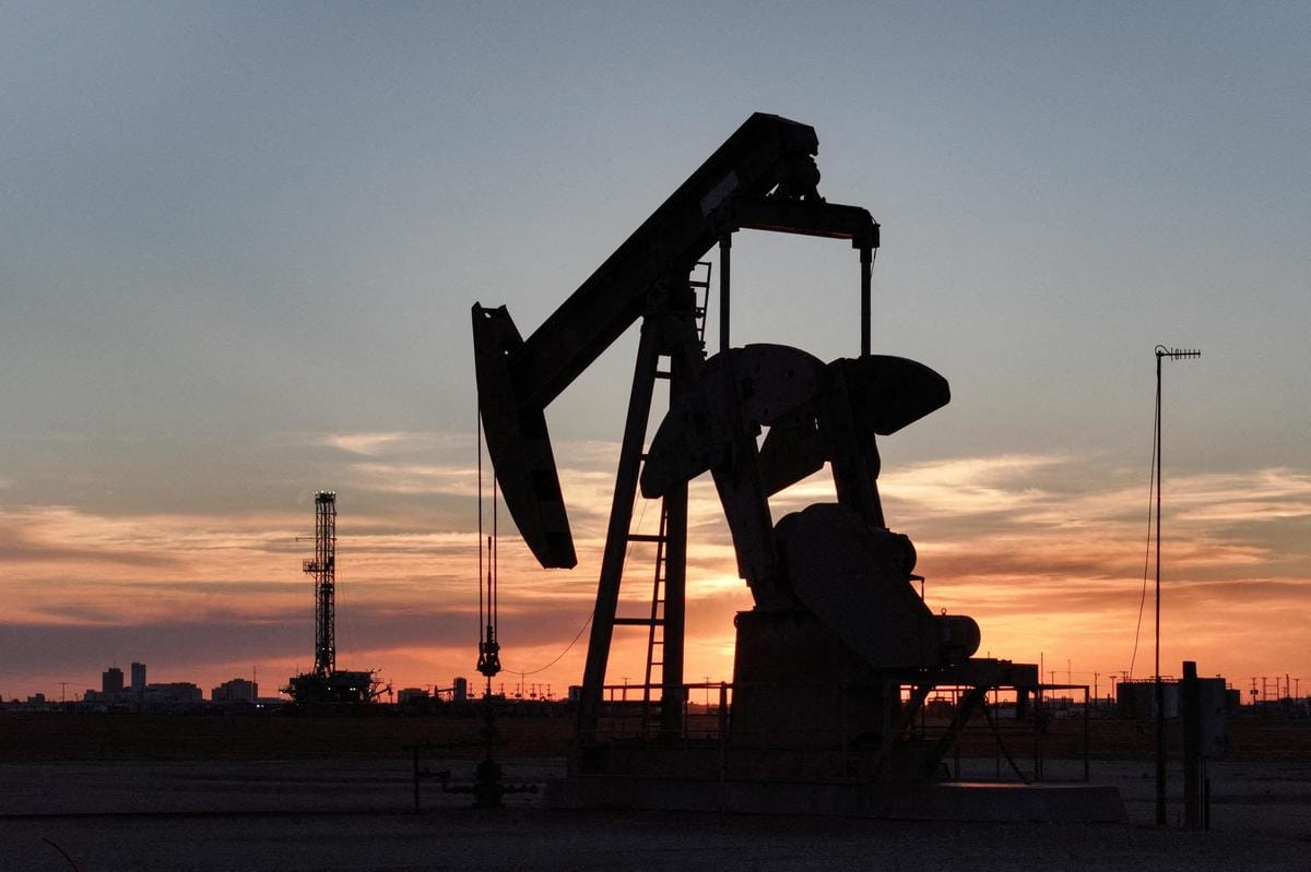 Silhouette of an oil pump jack against a sunset sky, US politics context.