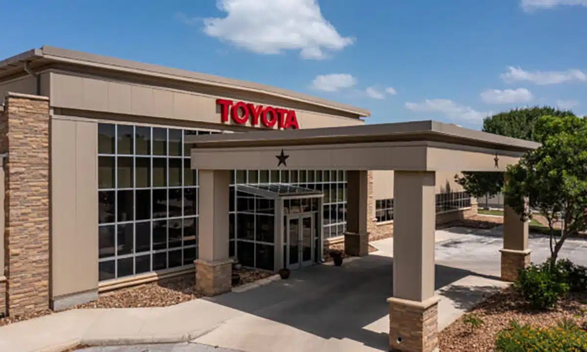 Toyota dealership exterior with "TOYOTA" signage, representing business investment.