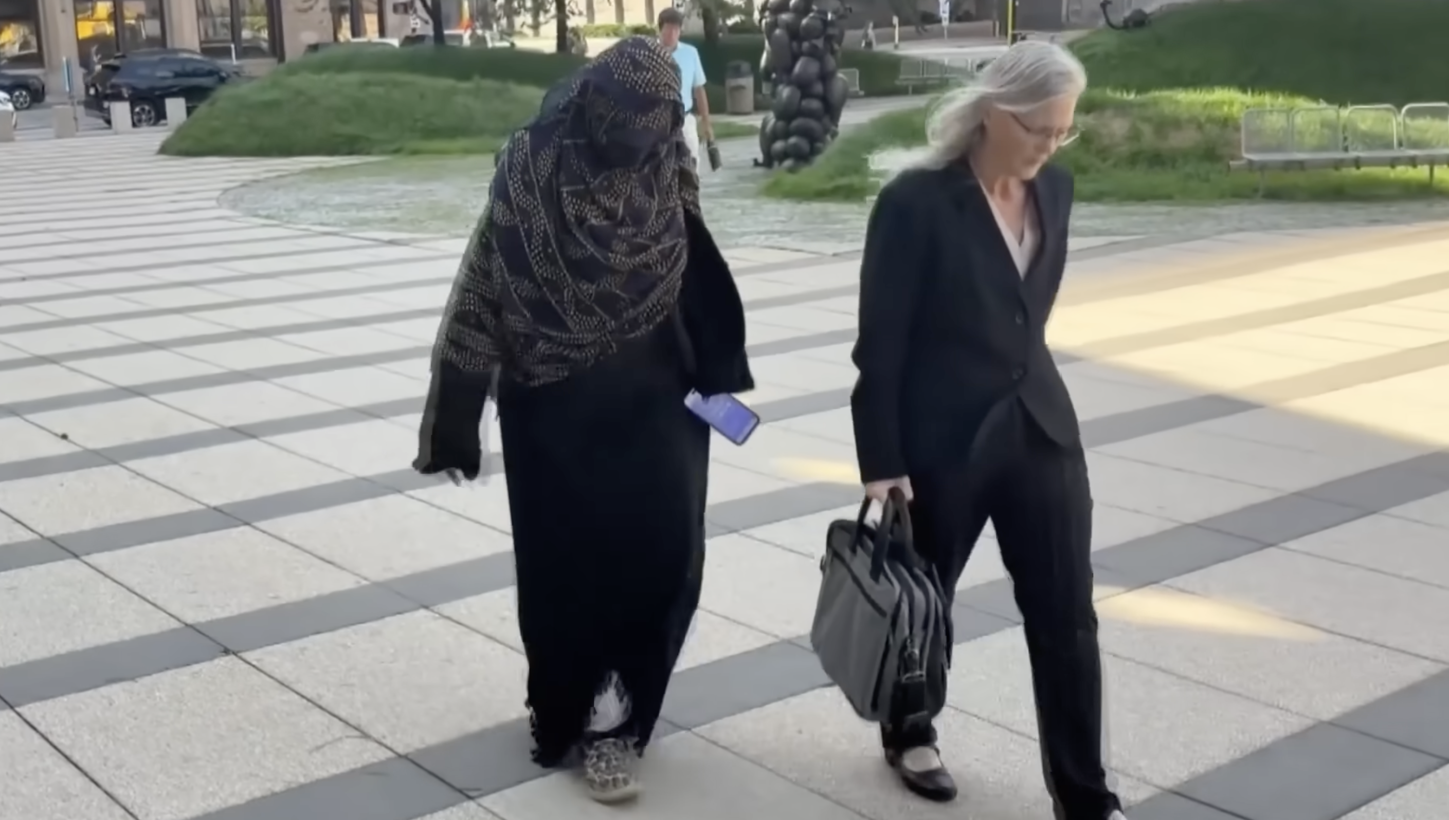 Daycare owner, accused of pandemic fraud, walks with lawyer in Minnesota.