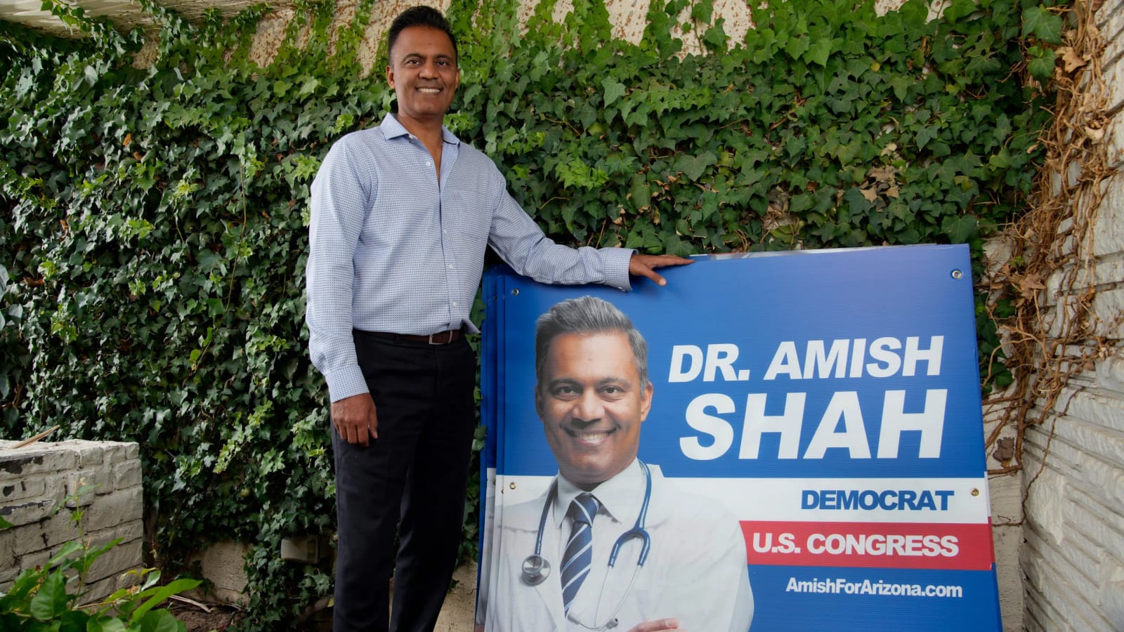 Dr. Amish Shah, Arizona Democrat for U.S. Congress, poses by campaign sign