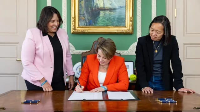 Massachusetts Governor Maura Healey signs bill for India Day, with other officials present.