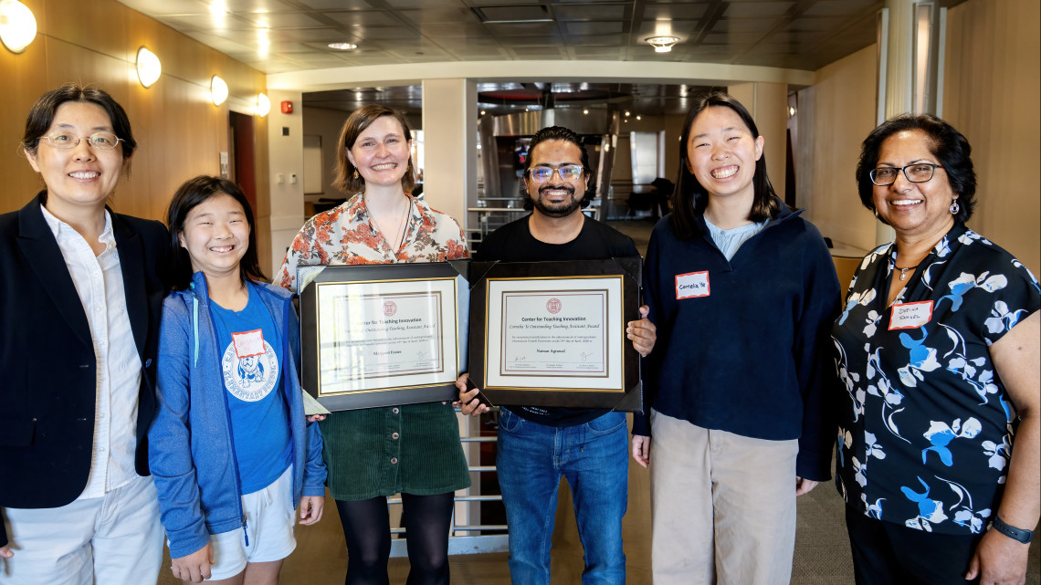 Naman Agrawal with Cornell teaching award, surrounded by colleagues.