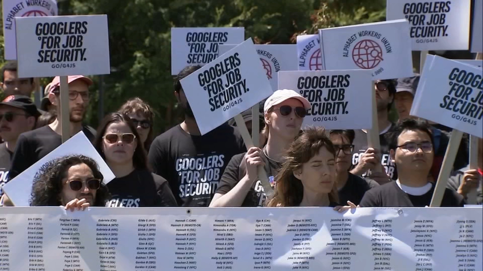 Google workers protest job security with "Googlers for Job Security" signs.