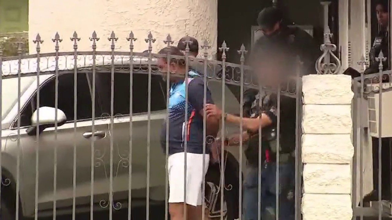 Man in handcuffs led by officers during L.A. sex trafficking arrest.