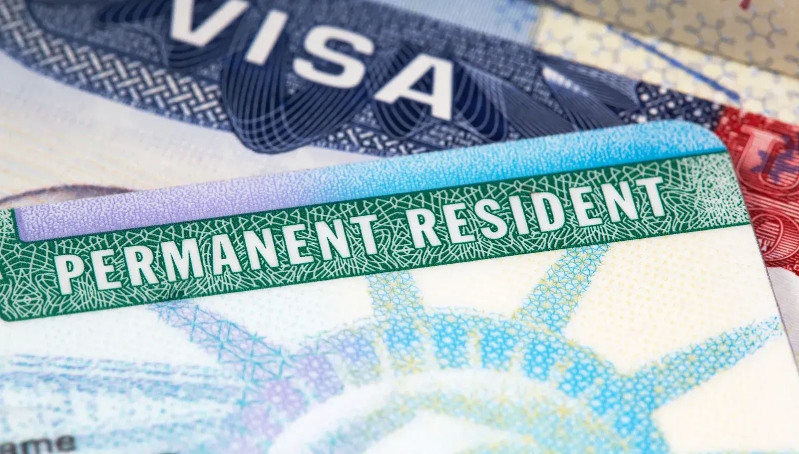 Close-up of a US Permanent Resident card (Green Card) and a visa.