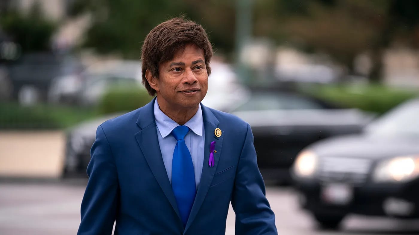 Shri Thanedar in blue suit with Democratic endorsement badge walking on street