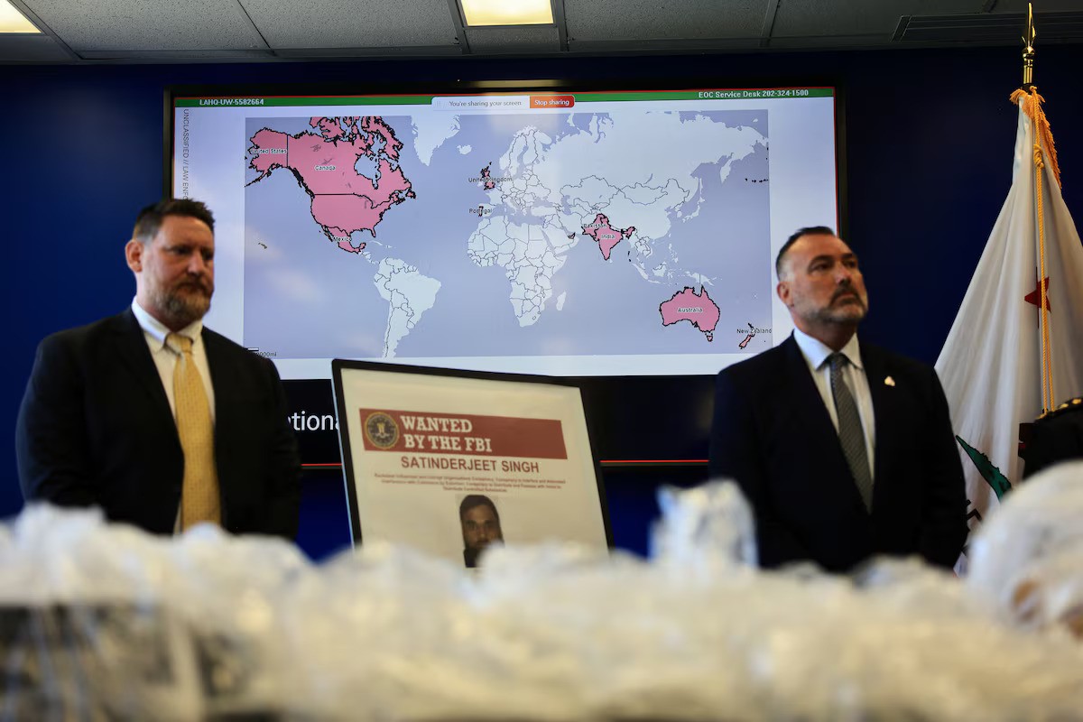FBI poster of Satinderjeet Singh with officials and world map