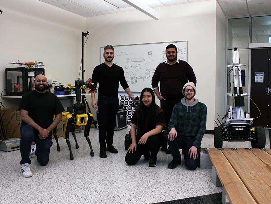 Nevada professor with students and farm robots